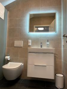 克尔贝格Gästehaus Veenstra的一间带卫生间、水槽和镜子的浴室