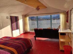 普诺Uros Quechua`s Lodge Titicaca的卧室配有床、浴缸和大窗户。