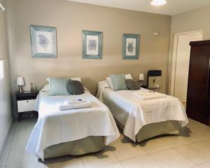 耶尔瓦布埃纳Departamento pie del cerro的一间卧室配有两张带白色和蓝色枕头的床