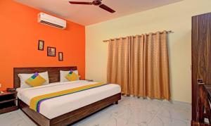 戈勒克布尔Itsy By Treebo - Royal Monarch的一间卧室配有一张橙色墙壁的床