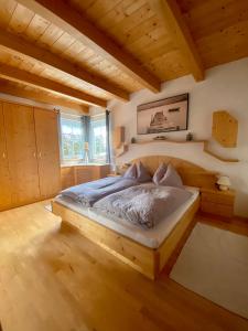 维尔德科格尔山麓布兰贝格AlpenApartment的一间带一张床的卧室,位于带木制天花板的房间内