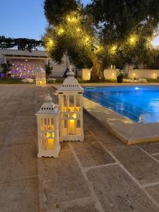 佩兹迪格雷科Costalta的两个白色灯笼,晚上坐在泳池旁
