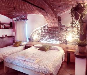瓦尔迪耶里路加仑鲁斯农家乐的一间卧室设有两张床和砖墙