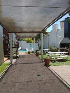 查斯科穆斯Portal del Sur的带顶棚的走道,配有野餐桌和长凳