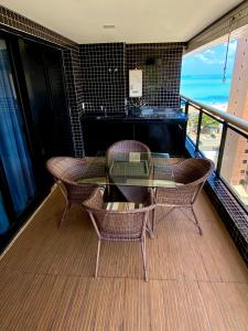 福塔莱萨Landscape Beira Mar Meireles的阳台配有玻璃桌、椅子和钢琴
