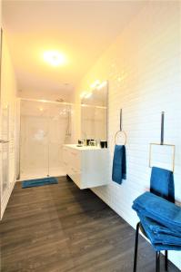 MagnantLes Bois de Champagne L'industriel的带淋浴和蓝色椅子的白色浴室