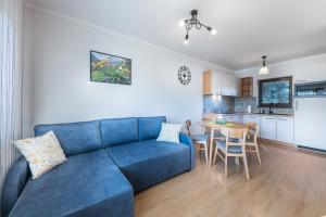 尤格Apartamenty ARNIKA的一间带蓝色沙发的客厅和一间厨房