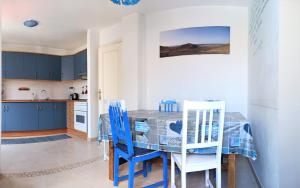 科拉雷侯The Spot House的厨房配有蓝色橱柜和桌椅