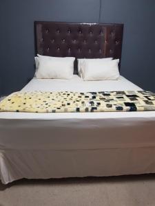 开普敦SALAMA LODGE的一张带床头板和枕头的床