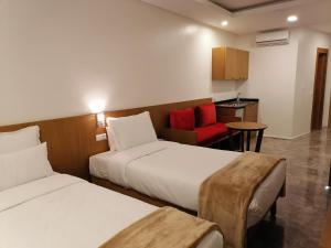 卡萨布兰卡Casa City Break Appart hôtel的酒店客房,设有两张床和一张红色椅子