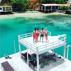 索科鲁塔拉岛度假村俱乐部酒店的站在水面上的一个码头上的四人