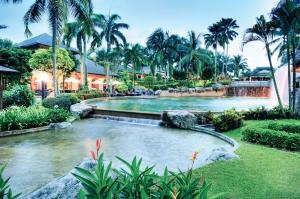 塞贝维塞贝维Spa度假酒店的一座拥有瀑布和棕榈树的度假村的游泳池