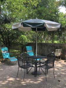 瓜达拉哈拉勒托诺住宿加早餐旅馆的庭院内桌椅和遮阳伞