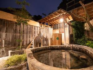白滨HOTEL SHIRAHAMAKAN的后院的热水浴池,设有木栅栏