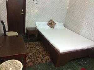 古瓦哈提Hotel Prince的一张小床,上面有枕头,放在一个房间里