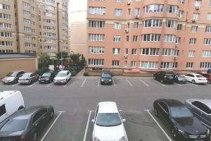 基辅044 Квартира в ЖК "София"的停车场,停车场的汽车停在大楼前
