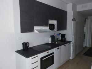 图尔库Vaunukatu的厨房配有白色橱柜和黑色台面