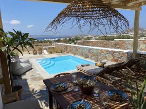 圣安娜纳克索斯Villa Ypsilon Naxos - luxury holiday house with amazing sea view & private pool的庭院设有游泳池和桌子