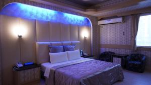 新竹风之海岸旅馆 的一间卧室,配有一张蓝色灯床
