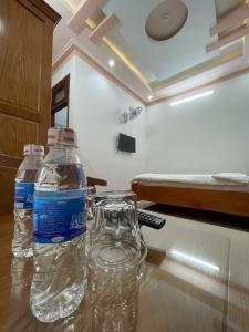 保禄Khách sạn Nguyên Long的两瓶水坐在房间里桌子上