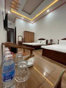 保禄Khách sạn Nguyên Long的客房设有两张床和一张带一瓶水的桌子。
