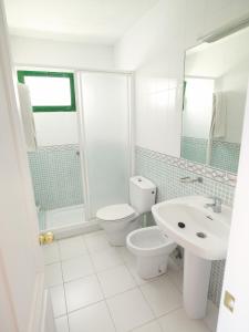 波多黎各巴巴鲁公寓的白色的浴室设有卫生间和水槽。