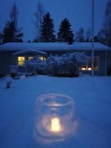罗瓦涅米Arctic Circle Tranquillity的屋前雪中蜡烛