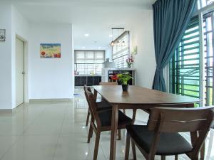 Bandar PenawarDesaru Comfy Home with Netflix Near Beach, Waterpark & BBQ的一间带木桌和椅子的用餐室