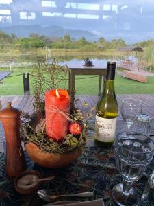 克拉格斯ECO Lodge Villa Villekula的一张桌子,上面放着一瓶葡萄酒和一碗水果