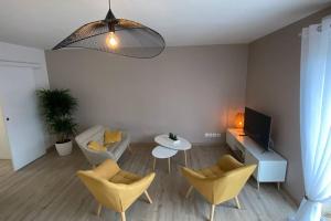 Saint-Julien-les-Villasappartement maison en duplex 80m² jardin terrasse的客厅配有黄色椅子和桌子