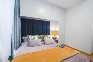 奥尔什丁Apartament Warmiński by RENT4YOU的一间卧室配有一张大床和蓝色床头板