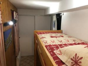 圣热尔韦莱班Petite Marmotte的一间卧室配有一张带红白毯子的床