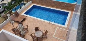 马塞约Apartamentos 250m da Orla -Edifício Nugali- Castelo B Temporada的享有带桌椅的游泳池的顶部景致