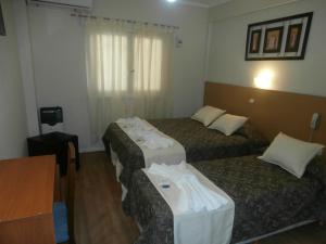马德普拉塔Hotel Alma di Mare的酒店客房,配有三张床和毛巾