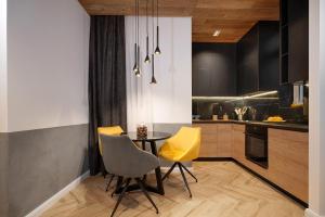 贝尔格莱德Luxury Apartments Donostia & Iruña的厨房配有桌子和2把黄色椅子