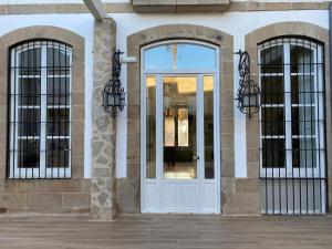 利纳雷斯HOTEL CASABLANCA BOUTIQUE的大楼的白色门,设有两扇窗户