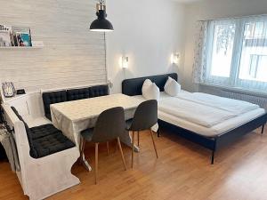 圣莫里茨Zentrale gemütliche Wohnung St Moritz - A212的卧室配有一张床和一张桌子及椅子