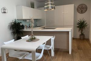 布列瑟农Apartments Griesser的白色的厨房配有白色的桌子和椅子