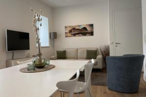 布列瑟农Apartments Griesser的白色的客厅配有白色的桌子和椅子