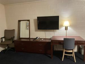 柴尔德里斯Childress Inn的一间房间,配有一张桌子和一台墙上的电视