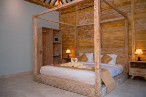 吉利特拉旺安Alwi Villa Gili Trawangan的一间卧室配有一张木架床