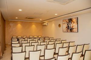 卢萨卡HOTEL AFRICANA LSK的一个带椅子和大屏幕的会议室