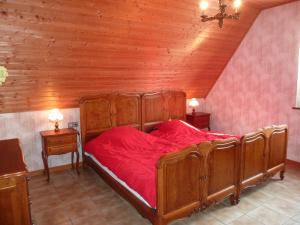 EpfigMarronnier的一间卧室配有一张铺有红色床单的木床。