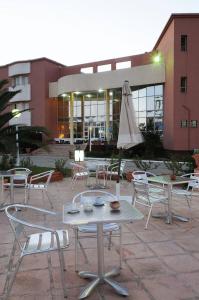 突尼斯度派克酒店的大楼前的桌椅和遮阳伞