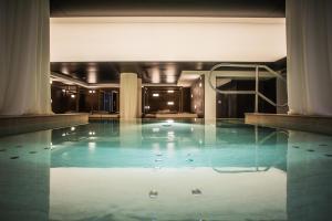 布伦托尼科Hotel San Giacomo Spa&Gourmet的大楼里一个蓝色的大泳池