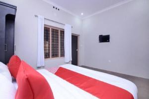 PanamaramWayal Wayanad Twin Villa的卧室里一张红色和白色的床,卧室里设有窗户