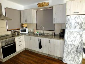 吉亚德伊索拉La Cabaña的厨房配有白色橱柜和水槽