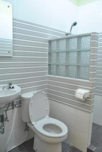 日惹日惹阿罗哈酒店的白色的浴室设有卫生间和水槽。