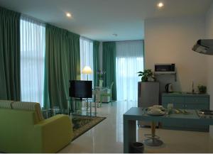米里MCITI套房酒店的客厅配有绿色窗帘、沙发和电视