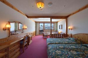 山之内町奥志贺凤凰大酒店的一间卧室配有一张床、一张桌子和一面镜子